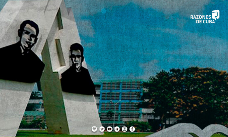 Estudiantes cubanos en toga y birrete celebrando su graduación en la Universidad Hermanos Saíz de Pinar del Río, con monumento de jóvenes al fondo.